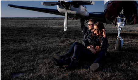 Couple sitting near a helicopter on a sunny day