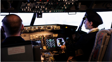 Female pilot operating cockpit controls in an airliner