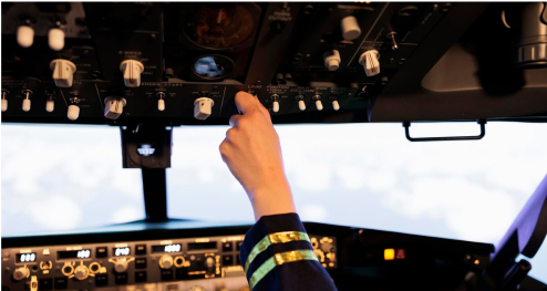 Female co-pilot adjusting cockpit controls during flight