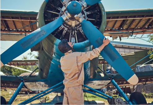 Pilot and mechanic inspecting a vintage aircraft propeller